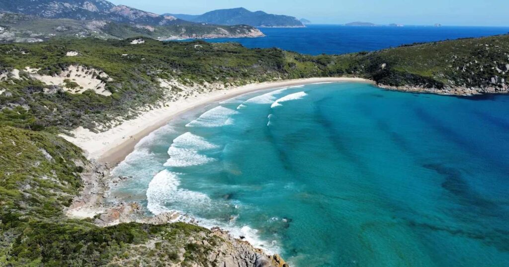 a picturesque shot of a beach with mountains and blue water